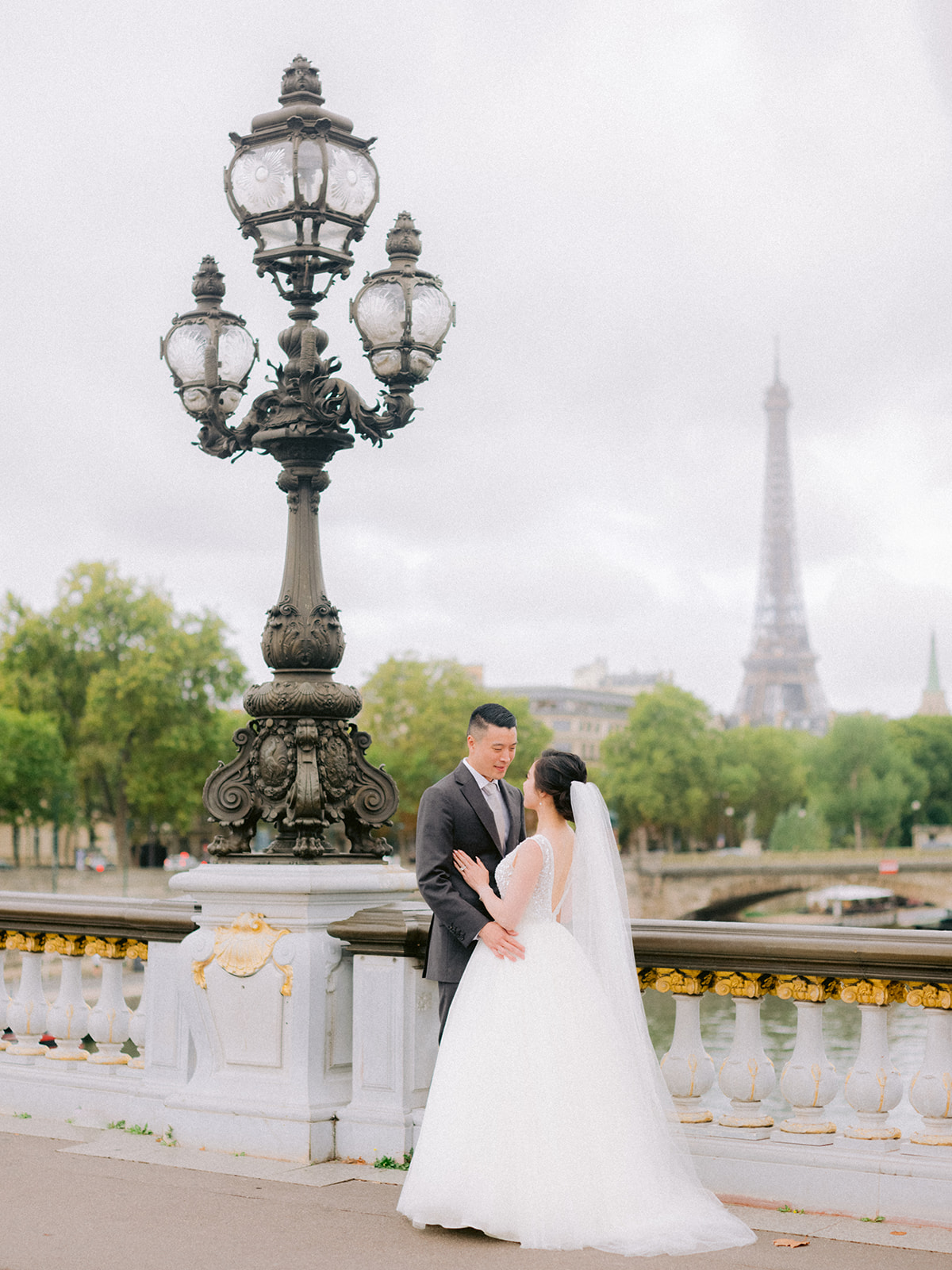 They are looking and standing on Alexander III Bridge